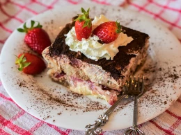 Assiette de Tiramisu à la Fraise, sur une table avec une nappe de pique nique rouge à carreaux blancs